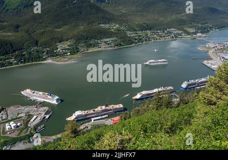Juneau, AK - 9. Juni 2022: Ansicht von fünf Kreuzfahrtschiffen im Hafen von Juneau mit Viking Orion vor Anker in der Bucht. Stockfoto