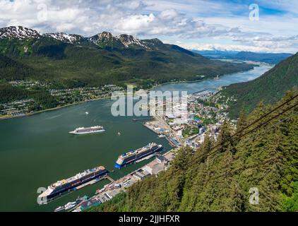 Juneau, AK - 9. Juni 2022: Ansicht von drei Kreuzfahrtschiffen im Hafen von Juneau mit Viking Orion vor Anker in der Bucht. Stockfoto