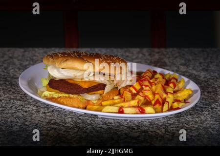 Ein Teller mit Rinderburger und pommes Frites mit Ketchup auf einem Marmortisch Stockfoto