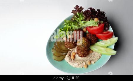 Arabisches Gericht, Hummus und Falafel mit frischem Gemüse. Auf weißem Hintergrund Stockfoto