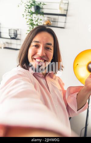 Ein junger erwachsener Mann, der im Raum in die Linse der Kamera schaut. Hochwertige Fotos Stockfoto