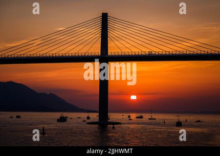 Die Sonne untergeht über der Peljesac-Brücke während der Eröffnungsfeier der Peljesac-Brücke am 26. Juli 2022 in Komarna, Kroatien. Foto: Zvonimir Barisin/PIXSELL Stockfoto