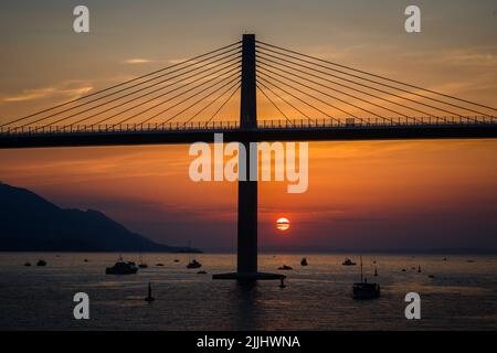 Die Sonne untergeht über der Peljesac-Brücke während der Eröffnungsfeier der Peljesac-Brücke am 26. Juli 2022 in Komarna, Kroatien. Foto: Zvonimir Barisin/PIXSELL Stockfoto