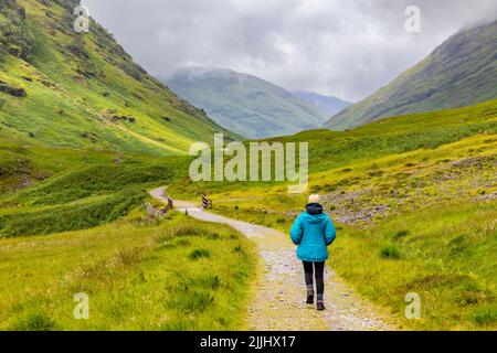 Glen Coe in den Highlands von Schottland, blonde weibliche Wanderer-Modell veröffentlicht in Wanderausrüstung Spaziergänge entlang der Glencoe Tal Trail, Schottland, Großbritannien Stockfoto