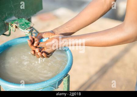 Nahaufnahme eines afroamerikanischen Arbeiters, der sich auf der Kaffeefarm die Hände wascht Stockfoto