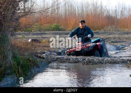 Ein Blick auf das Leben in Neuseeland: Flussüberquerungen und Schlammschlamm auf dem Quadbike üben: Oft der einzige Weg, um die besten Angelplätze zu erreichen. Stockfoto