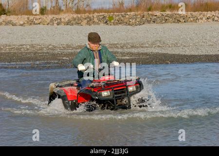 Ein Blick auf das Leben in Neuseeland: Flussüberquerungen und Schlammschlamm auf dem Quadbike üben: Oft der einzige Weg, um die besten Angelplätze zu erreichen. Stockfoto