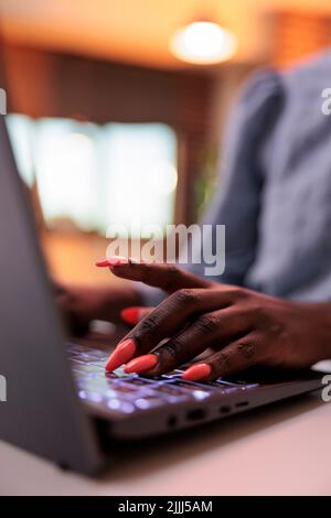 Junge afroamerikanische Freiberuflerin, die auf der Laptop-Tastatur tippt, Nahsicht auf den Händen. Geschäftsfrau im Internet surfen, E-Mails am Computer schreiben, sich auf gepflegte Nägel konzentrieren Stockfoto