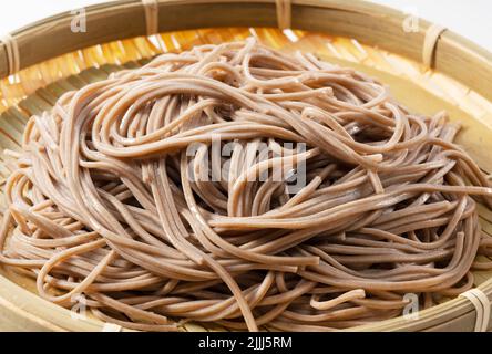 Zaru soba (Buchweizennudeln) auf weißem Hintergrund platziert. Zaru Soba ist ein traditionelles japanisches Essen. Stockfoto