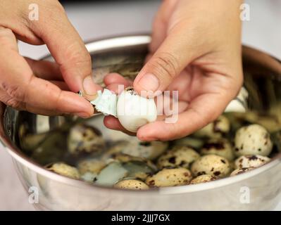 Asiatische Alte Frau Hand Peel Wachtel Ei Stockfoto