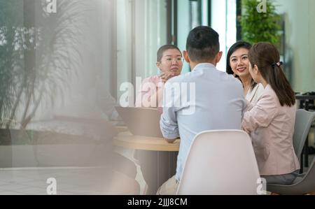 Geschäftsleute, asiatische Ethnie, die sich an einem Tisch treffen. Speicherplatz kopieren. Stockfoto