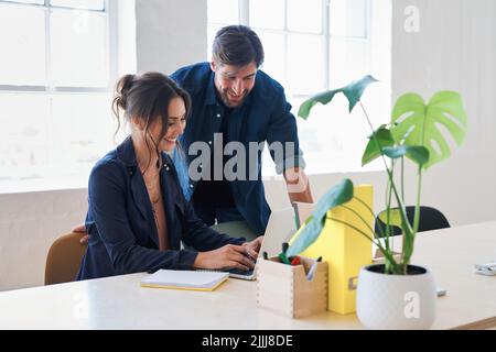 Zwei Geschäftsleute, die Kollegen mit Laptop-Computern im Büro nutzen, teilen sich Ideen Stockfoto