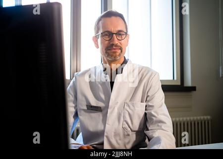 22. Juli 2022, Hessen, Frankfurt/Main: Gernot Rohde, Leiter Pneumologie am Universitätsklinikum Frankfurt, sitzt in seinem Sprechzimmer. Zusammen mit einem Kollegen leitet er auch die Long Covid Ambulanz. (An dpa: 'Lange Wartelisten für Patienten mit Covid-Spätfolgen in Hessen') Foto: Frank Rumpenhorst/dpa Stockfoto