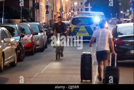 Berlin, Deutschland. 26.. Juli 2022. Vor dem St. Hedwig Krankenhaus in Mitte stehen Polizeinotfallfahrzeuge. Nachdem ein Mann Polizisten im Hof eines Berliner Krankenhauses angegriffen hatte, schossen die Polizisten auf ihn und verletzten ihn schwer. Dem Bericht zufolge versuchten die Polizeibeamten zunächst reizend Gas und feuerten schließlich Schüsse auf den Mann ab. Quelle: Paul Zinken/dpa/Alamy Live News Stockfoto