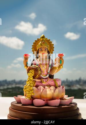 Hinduistischer Kosmos Maha laxshmi Statue mit Blumengirlande mit Naturhintergrund verziert. Statue der Göttin des Reichtums, Raum für Text, selektiver Fokus. Stockfoto