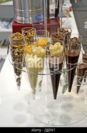 Tassen Haufen mit verschiedenen Dessert in transparenten Kegel Nahaufnahme, köstliche Dessert Zucker Eis Lebensmittel Vielfalt Stockfoto