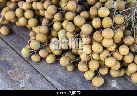 Longan Früchte auf Holzhintergrund, ein paar frische longan tropische Früchte in Thailand - Dimocarpus longan Stockfoto