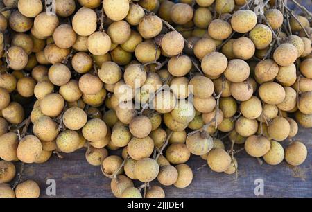 Longan Früchte auf Holzhintergrund, ein paar frische longan tropische Früchte in Thailand - Dimocarpus longan Stockfoto