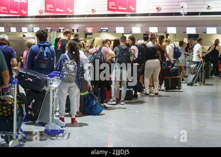 27. Juli 2022, Hessen, Frankfurt/Main: Passagiere warten morgens an den Check-in-Schaltern am Frankfurter Flughafen auf einen der wenigen Flüge, die an diesem Tag stattfinden. Aufgrund des Verdi-Warnstreiks hat Lufthansa fast ihren gesamten Flugplan für Mittwoch abgesagt. Foto: Frank Rumpenhorst/dpa Stockfoto