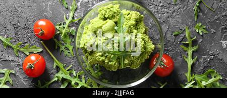 Frische Guacamole in Glasschüssel auf dem Tisch, Draufsicht Stockfoto