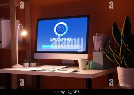 Stilvoller Arbeitsplatz mit modernem Computer am Abend. Konzept der Aktualisierung Stockfoto