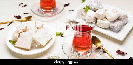 Glas-Tasse leckeren türkischen Tee mit Süßigkeiten auf weißem Tisch Stockfoto