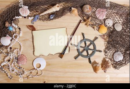 Leeres Papier mit verbrannten Kanten auf Holzhintergrund mit Meeresmuscheln und Fischernetz. Nautisches und Küstenthema Stockfoto