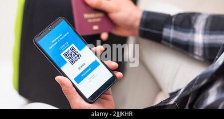 Impfpass, Reisender Mann mit Gesundheitspass der Impfpass-Zertifizierung auf Smartphone-App am Flughafen vor dem Einsteigen in das Flugzeug während der coro Stockfoto