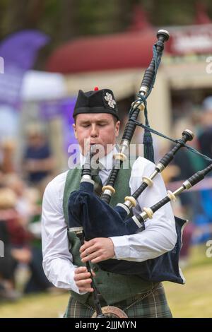Highland-Spiele, die am 17. Juli 2022 in Tomintoul Moray in Schottland stattfinden, spielt ein schottischer Mann vor der Jury in Schottland, Großbritannien, die Dudelsäcke Stockfoto