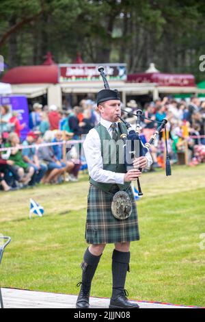 Highland-Spiele, die am 17. Juli 2022 in Tomintoul Moray in Schottland stattfinden, spielt ein schottischer Mann vor der Jury in Schottland, Großbritannien, die Dudelsäcke Stockfoto