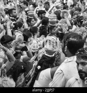 Delhi, Indien April 03 2022 - Frauen mit Kalash am Kopf während des Jagannath-Tempels Mangal Kalash Yatra tragen indische Hindu-Anhänger irdische Töpfe im Container Stockfoto