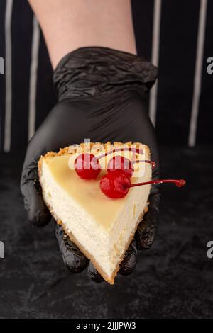 Klassischer Käsekuchen mit Kirschen auf dunklem Hintergrund. Stockfoto