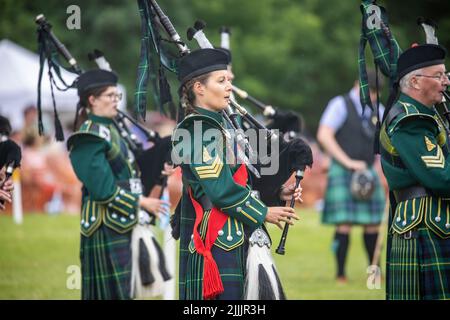 Junge weibliche Dudelsackspielerinnen bei den Spielen der Tomintoul 2022 Highland in der schottischen Pfeifenband Huntley and District, Schottland, Großbritannien Stockfoto