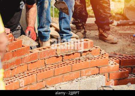 Maurer arbeiten an einer gebogenen Wand Stockfoto