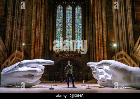 Der Künstler Peter Walker mit seinem Werk Connection, einer zeitgenössischen Variante von Michelangelos Meisterwerk The Creation of Adam, Teil seiner Ausstellung Being Human in der Liverpool Cathedral. Bilddatum: Dienstag, 26. Juli 2022. Stockfoto