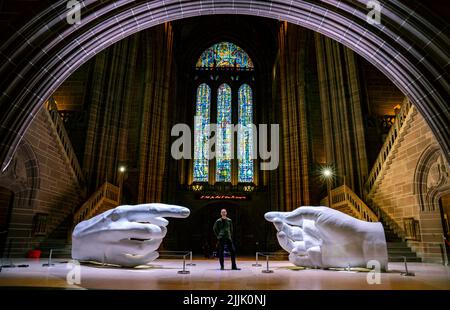 Der Künstler Peter Walker mit seinem Werk Connection, einer zeitgenössischen Variante von Michelangelos Meisterwerk The Creation of Adam, Teil seiner Ausstellung Being Human in der Liverpool Cathedral. Bilddatum: Dienstag, 26. Juli 2022. Stockfoto