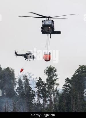 Hrensko, Tschechische Republik. 27.. Juli 2022. Im tschechischen Nationalpark Böhmische Schweiz in Hrensko nahe der Grenze zu Sachsen werden Hubschrauber zum Löschen eines Waldbrands eingesetzt. Kredit: Robert Michael/dpa/Alamy Live Nachrichten Stockfoto