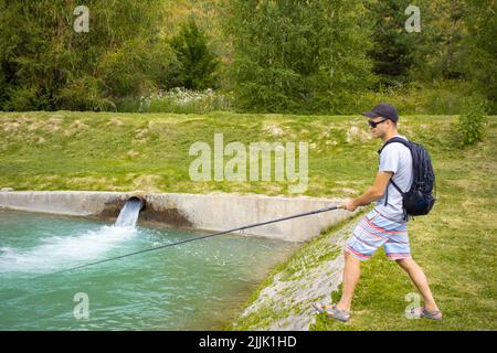 Angeln auf einer Forellenfarm. Ein Kerl fischt auf einer Forellenfarm Stockfoto