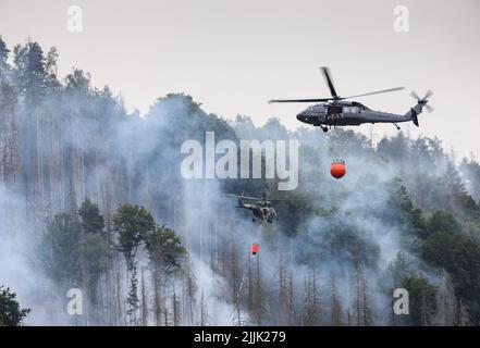 Hrensko, Tschechische Republik. 27.. Juli 2022. Im tschechischen Nationalpark Böhmische Schweiz in Hrensko nahe der Grenze zu Sachsen werden Hubschrauber zum Löschen eines Waldbrands eingesetzt. Kredit: Robert Michael/dpa/Alamy Live Nachrichten Stockfoto