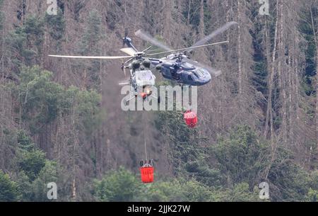 Hrensko, Tschechische Republik. 27.. Juli 2022. Im tschechischen Nationalpark Böhmische Schweiz in Hrensko nahe der Grenze zu Sachsen werden Hubschrauber zum Löschen eines Waldbrands eingesetzt. Kredit: Robert Michael/dpa/Alamy Live Nachrichten Stockfoto