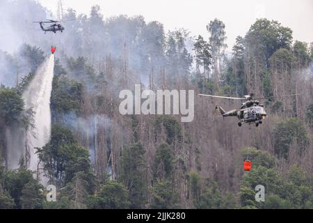 Hrensko, Tschechische Republik. 27.. Juli 2022. Im tschechischen Nationalpark Böhmische Schweiz in Hrensko nahe der Grenze zu Sachsen werden Hubschrauber zum Löschen eines Waldbrands eingesetzt. Kredit: Robert Michael/dpa/Alamy Live Nachrichten Stockfoto