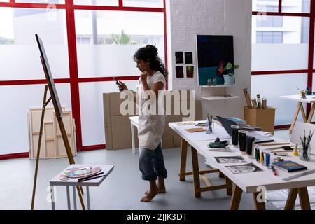 Bild von Biracial Künstlerin Foto von neuen Malerei im Studio Stockfoto