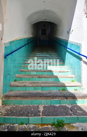 Eine vertikale Aufnahme einer alten, schmalen Treppe, die in Vietri sul Mare, Italien, hinaufführt Stockfoto