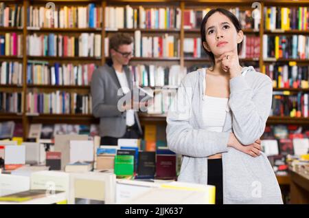 Studentin, die in der Bibliothek steht Stockfoto