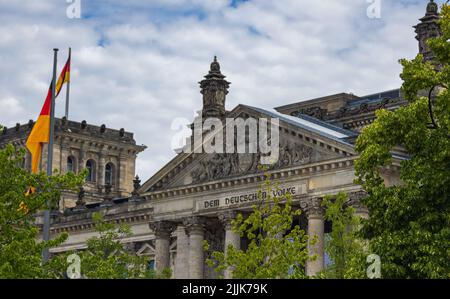 Berlin, Deutschland - 29. Juni 2022: Das Reichstagsgebäude, Sitz des deutschen bundestages. Die deutsche Flagge auf einem Fahnenmast. Der Eingang wi Stockfoto