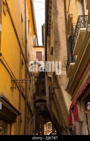 Treviso, Italien - 24.. Juli 2022. Die enge mittelalterliche Calle del Podesta Straße zeigt Bogenstützen für überhängende Jetbining auf der rechten Seite Stockfoto