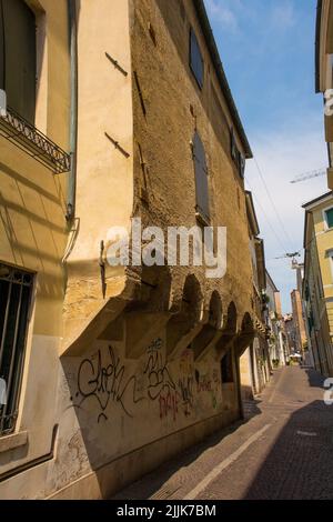 Treviso, Italien - 23.. Juli 2022. Ein Gebäude in der engen mittelalterlichen Via Castelmenardo Straße, das Bogenstützen für überhängende Jetbining zeigt Stockfoto