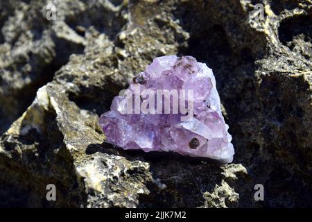 Ein schöner Amethyst drusen liegt auf einem Stein. Ein Spleiß aus violetten Kristallen aus semi-edlem Quarz. Stockfoto