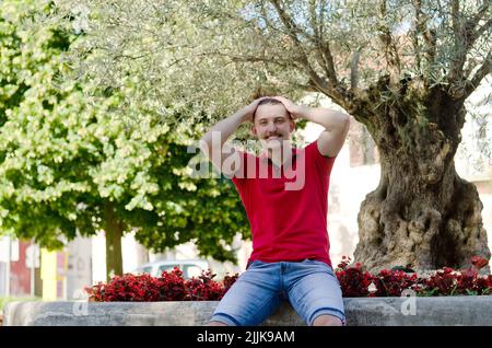 Junger glücklicher, gutaussehender bärtiger Mann, Tourist, der in der Altstadt von Koper spazieren geht. Sommerurlaub. Sonnenbrille. Lifestyle-Porträt Stockfoto