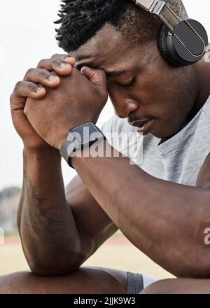 Ich habe mich heute im Stich gelassen. Ein sportlicher junger Mann, der seine Kopfhörer trägt, während er zum Training unterwegs ist. Stockfoto